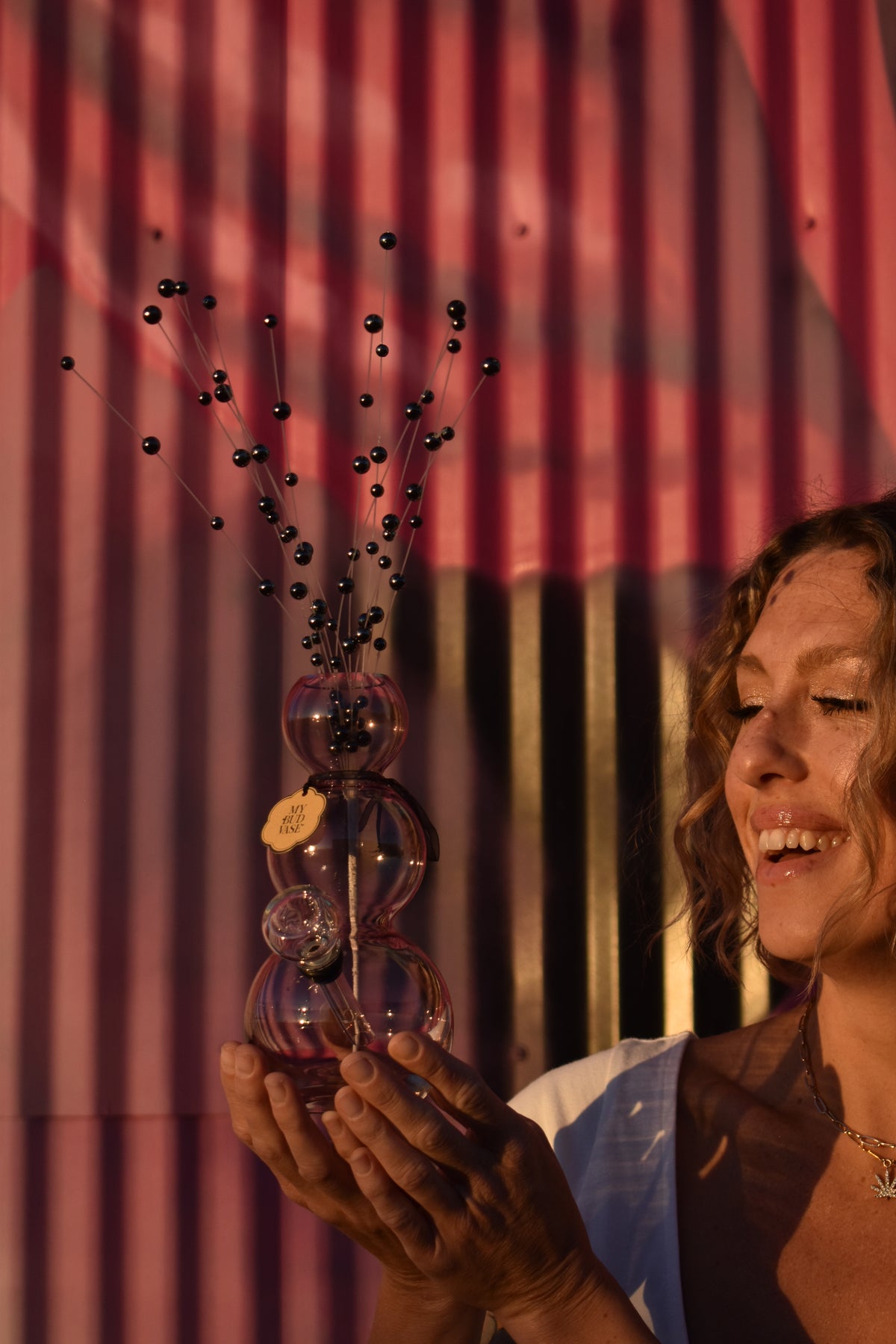 Photo of a woman holding the My Bud Vase metallic grey Bubbles vase bong. 