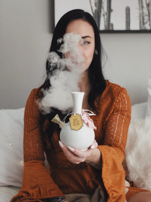Woman smoking from a beautiful white bud vase peaceful serene