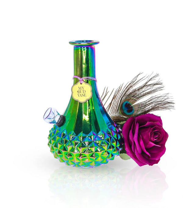 Beautiful iridescent bong that looks like a flower vase. Made to look like carnival glass this vase shines in different colors. Comes with a purple bowl or slide to match and a peacock feather and faux purple rose to disguise your bong into a vase.  