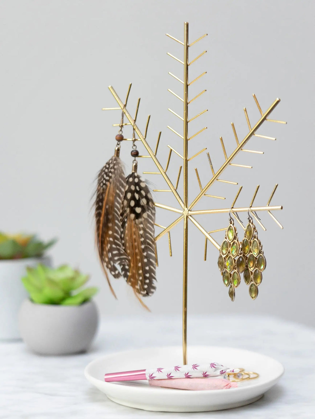 Display and organize your jewelry with this distinctively designed Cannabis Leaf Jewelry Tree and ivory ceramic dish with feather earrings and a pink rolled joint. 